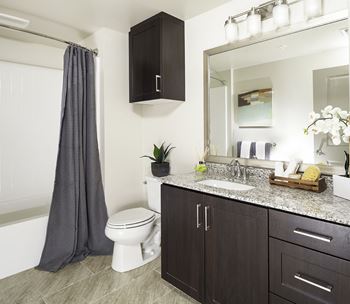 Elegant primary bathrooms with tile floors and framed mirrors